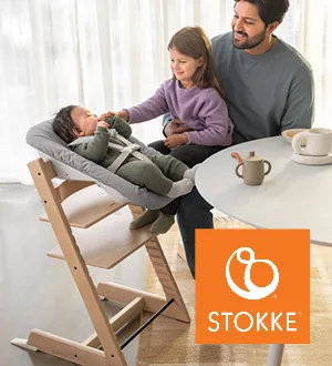Ein Vater und eine Tochter sitzen an einem Tisch neben einem Baby in einem Tripp Trapp Hochstuhl von Stokke.