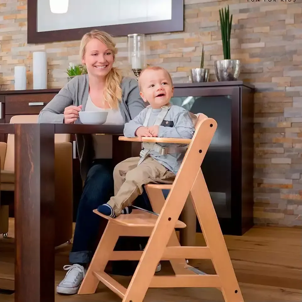 Eine frau, die mit ihrem baby auf einem hochstuhl sitzt.