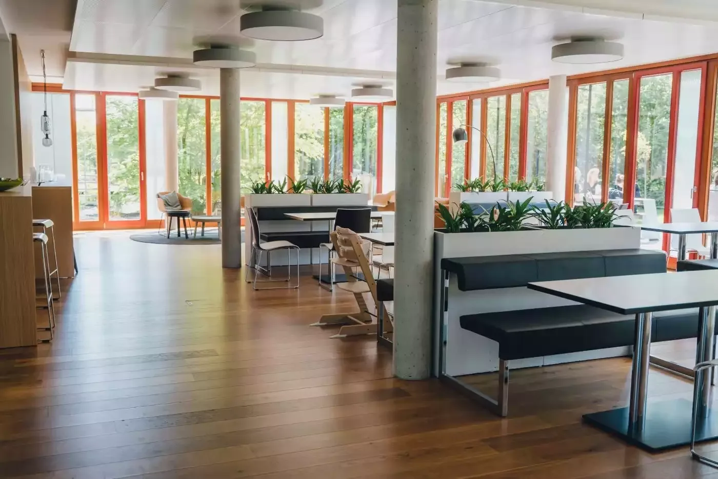 Büro ein modernes mit holzböden und großen fenstern.
