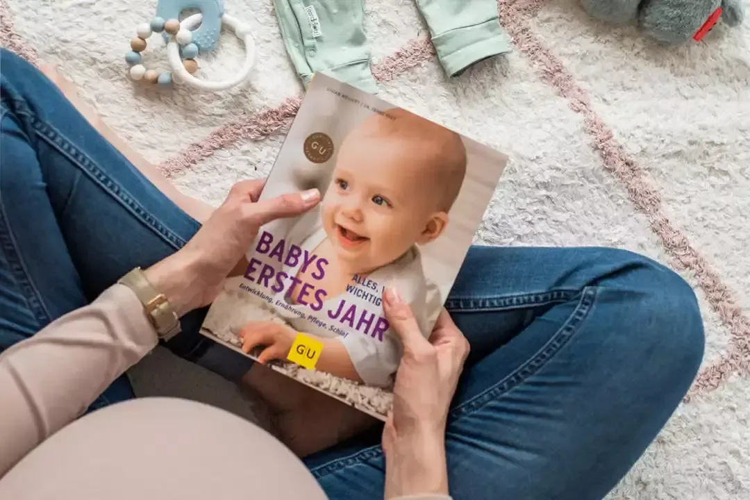 Eine frau, die auf dem boden sitzt und ihrem baby.