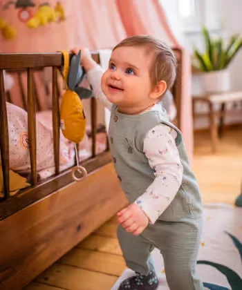 Baby ein spielt mit einem spielzeug in einer krippe.