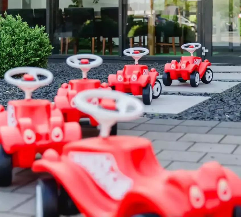 Eine gruppe roter rennwagen, die vor einem gebäude stehen gemeinsam.