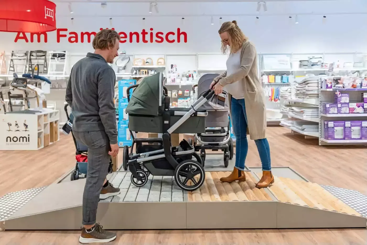 Ein mann und eine frau stehen gemeinsam neben einer baby-kutsche in.