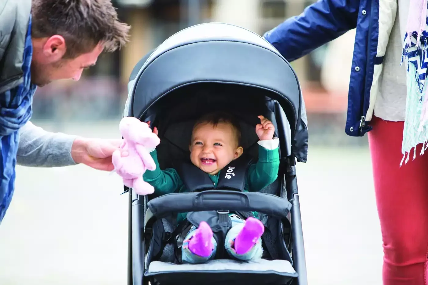 Eine frau, die ein baby in einem kinderwagen hält.