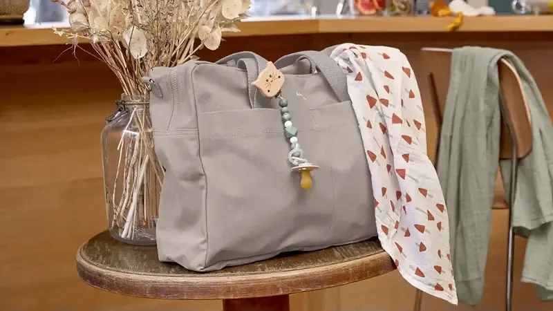 Tasche eine graue, die auf einem holzstuhl sitzt.