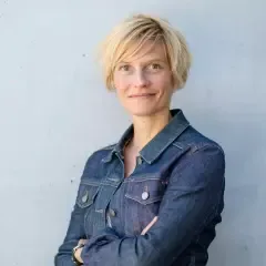 Eine frau mit blonden haaren und einer jeansjacke.