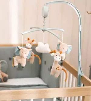 Ein Baby-Mobilé mit niedlichen Stofftieren ist sicher am Rand eines Gitterbettes befestigt.