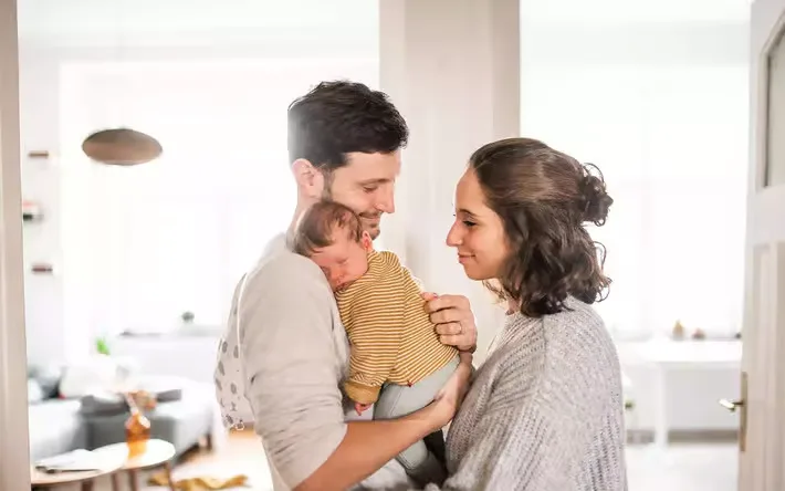 Ein mann und eine frau, die ein baby in ihren.