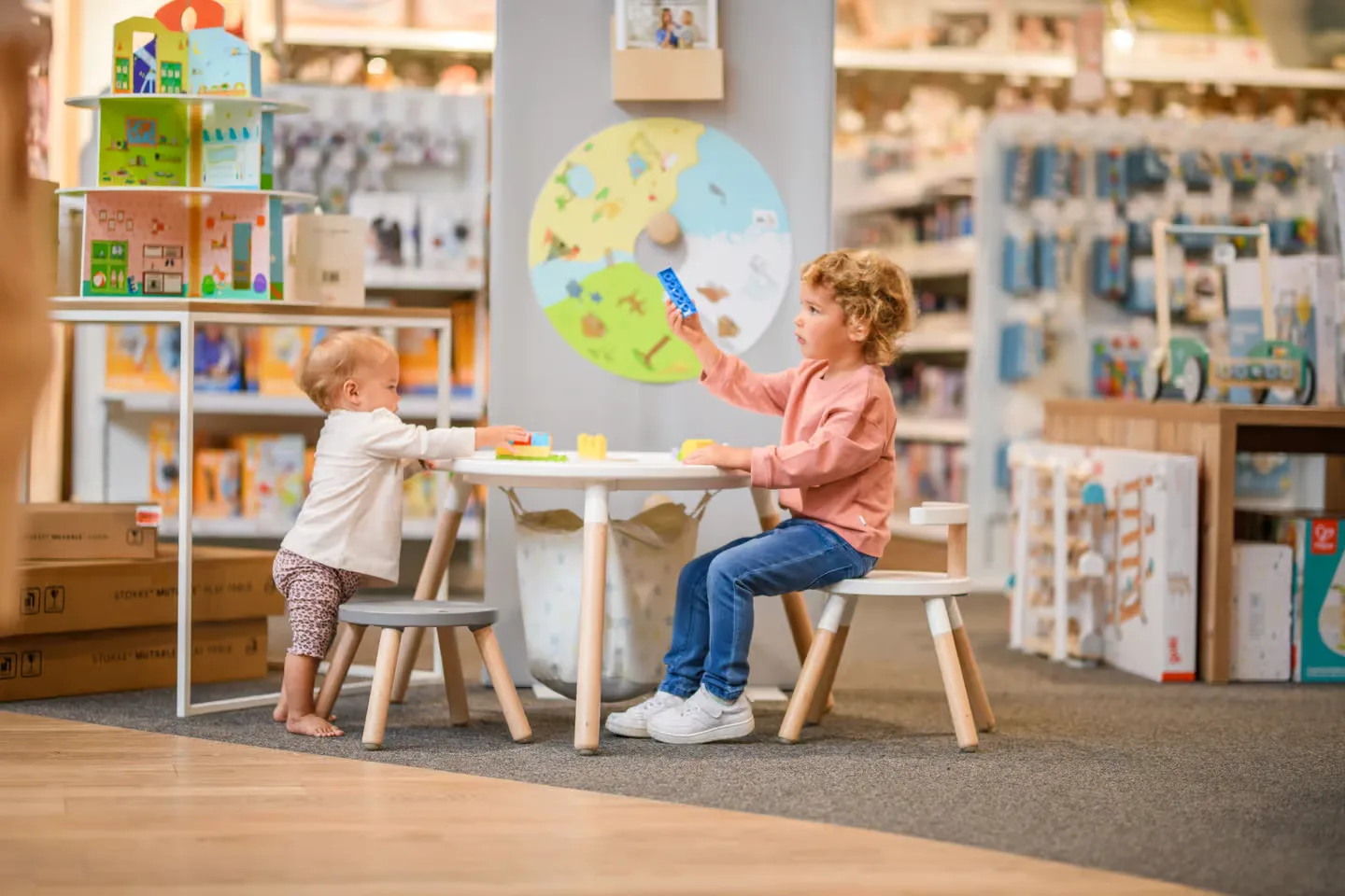 Zwei Kinder spielen gemeinsam in einem farbenfrohen Spielzimmer.