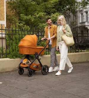 Ein Paar geht mit einem Kinderwagen spazieren.