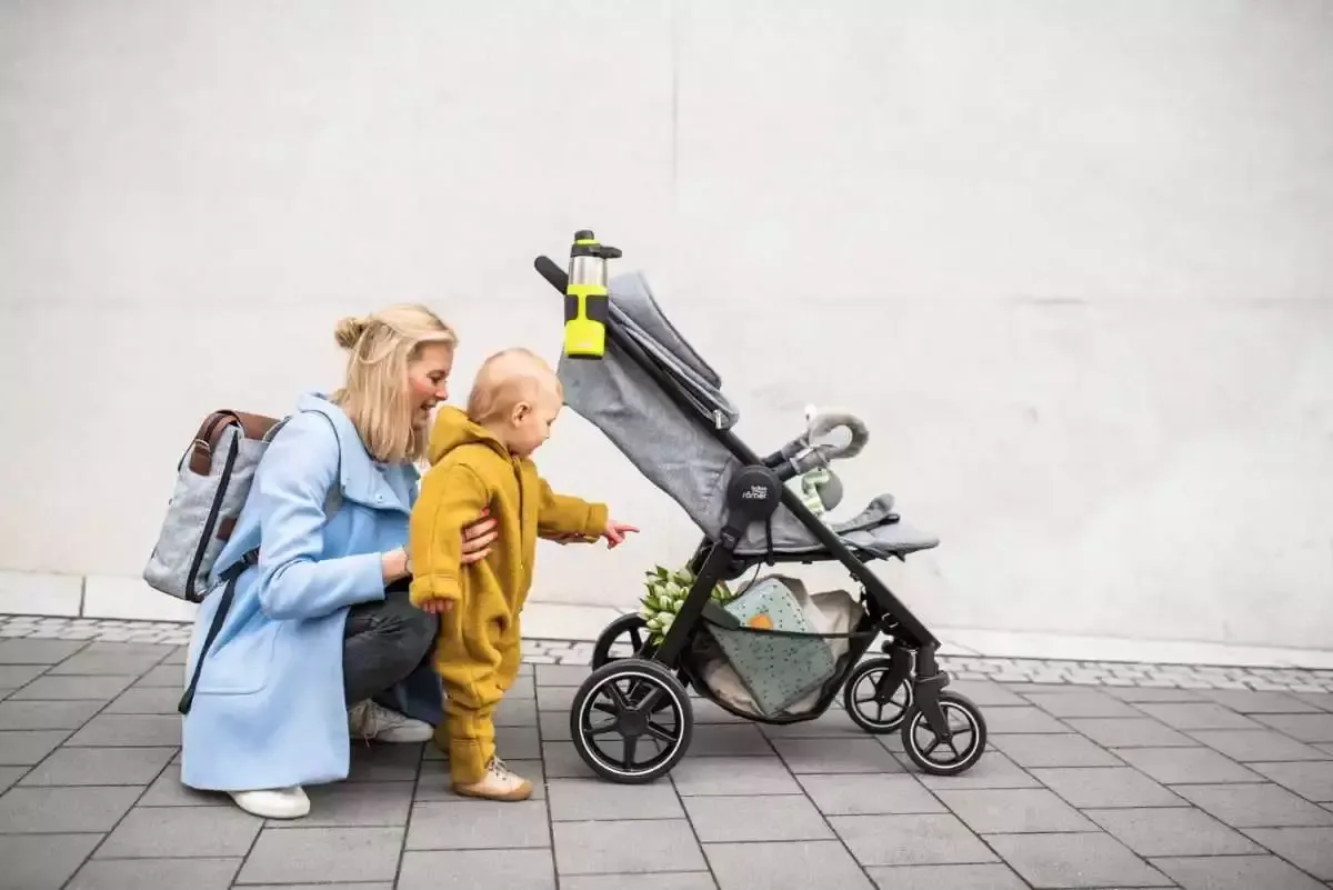 Eine frau in einem gelben mantel und ein baby in.