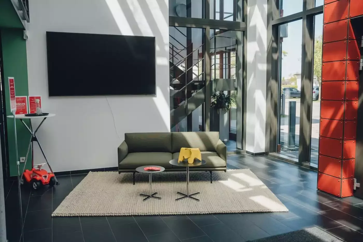Wohnzimmer ein mit einer grünen couch und einem fernseher.
