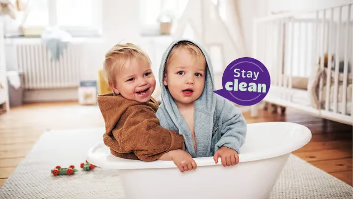 Zwei Babys sitzen in einer kleinen Badewanne