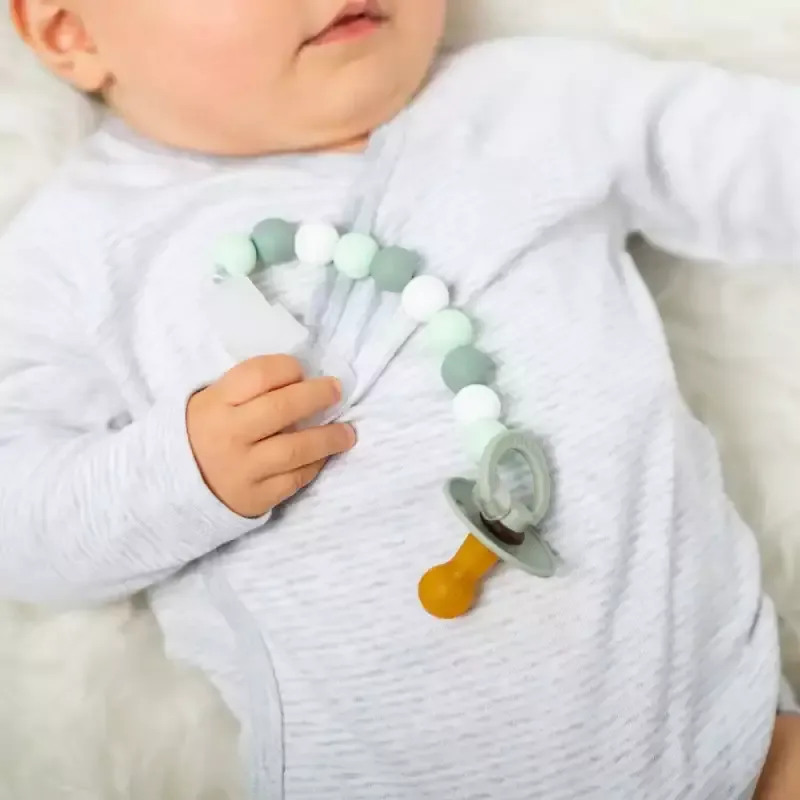 Baby ein, das auf einer weißen decke liegt.