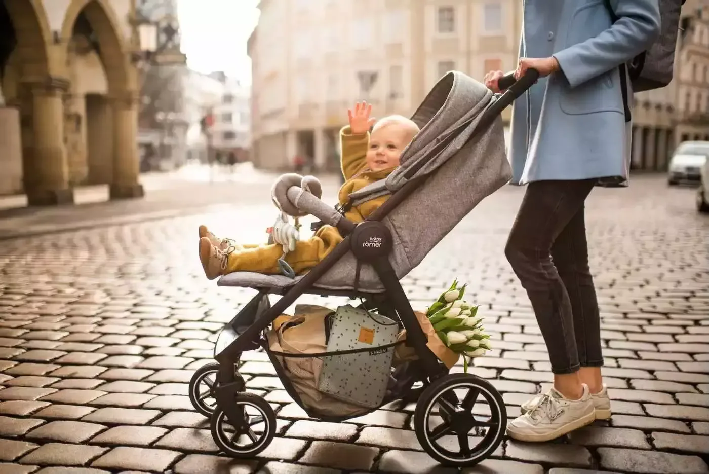 Eine frau, die ein baby in einen kinderwagen schiebt.