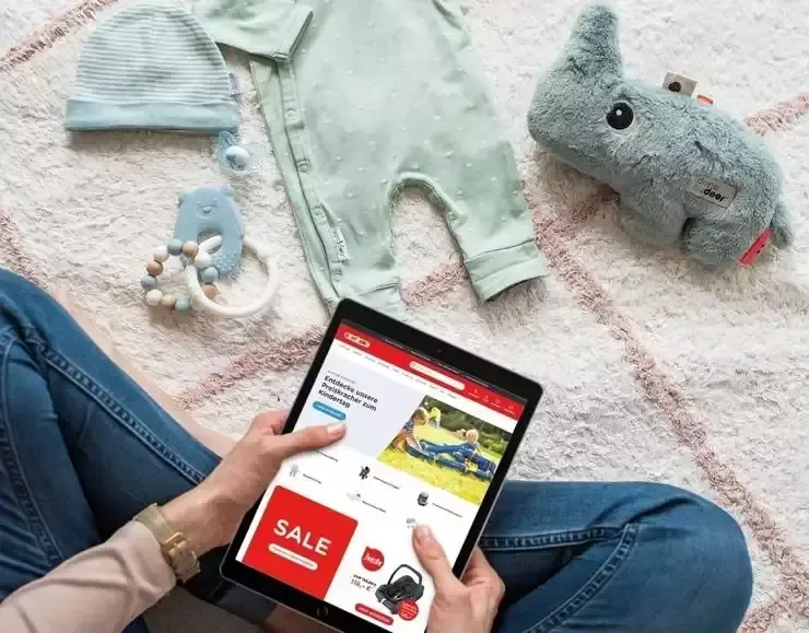 Eine frau, die auf dem boden sitzt und eine tablette.