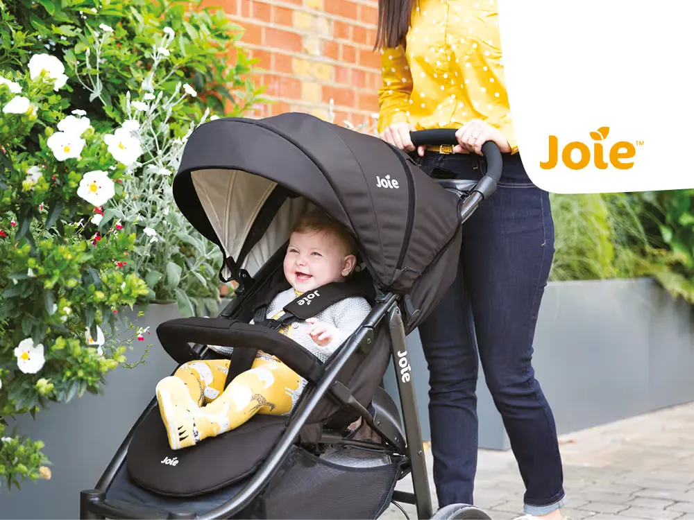Eine frau, die ein baby in einen kinderwagen schiebt.