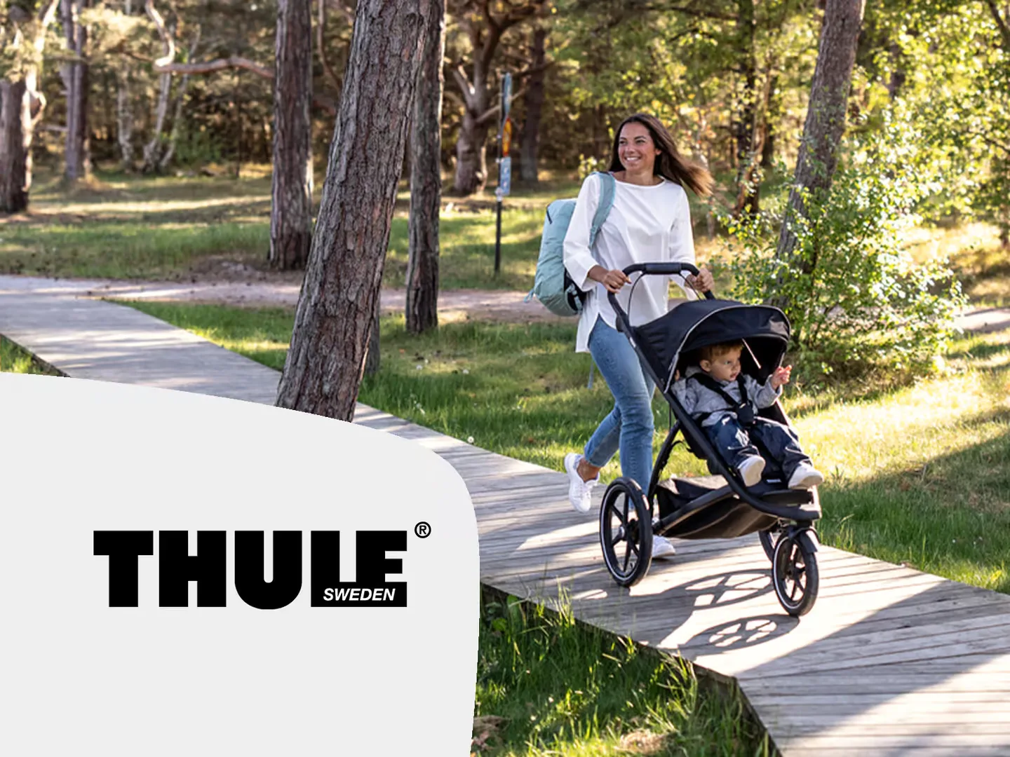 Eine frau, die mit einem baby in einem kinderwagen geht.