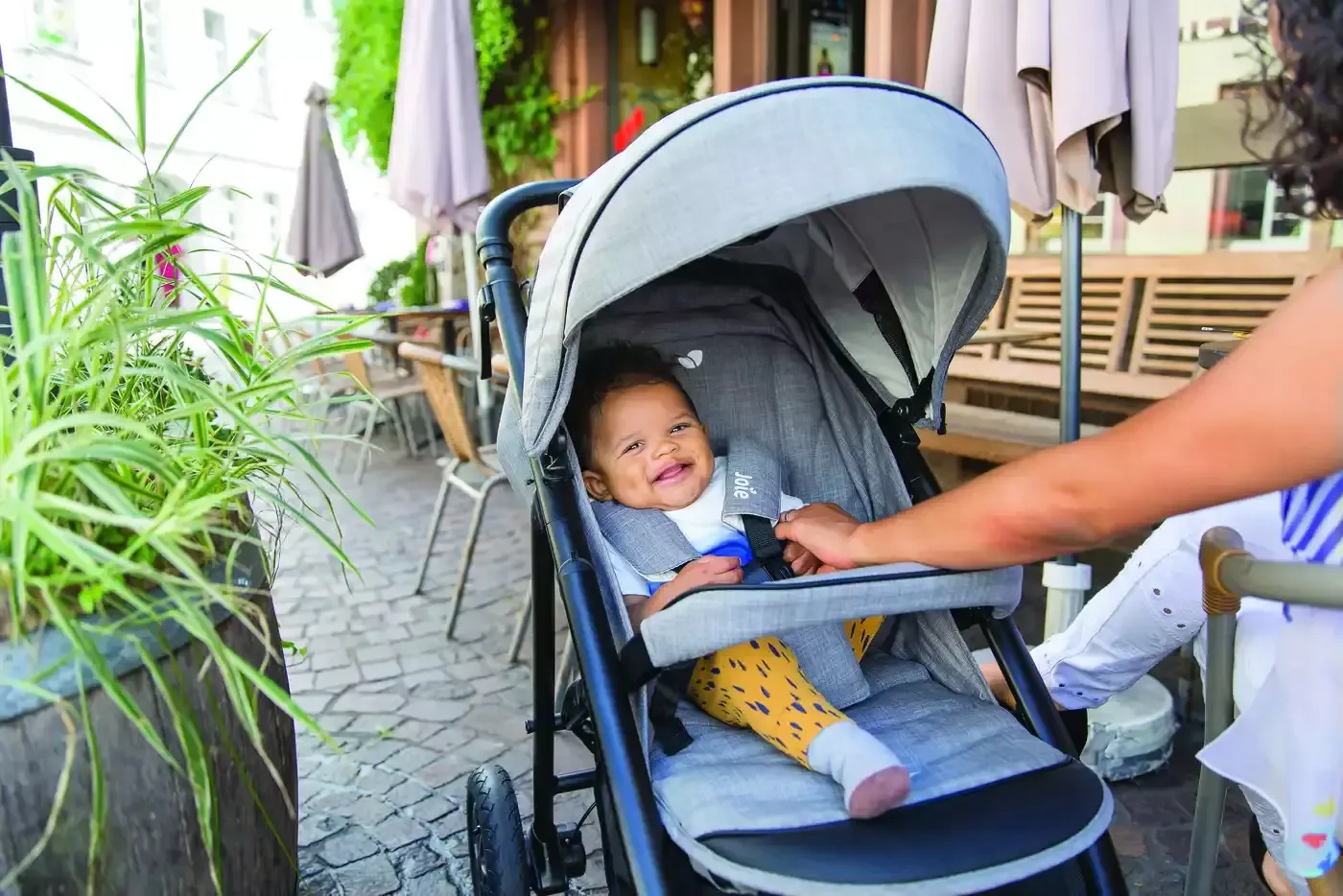 Baby ein in einem kinderwagen, das von einer frau gefüttert.