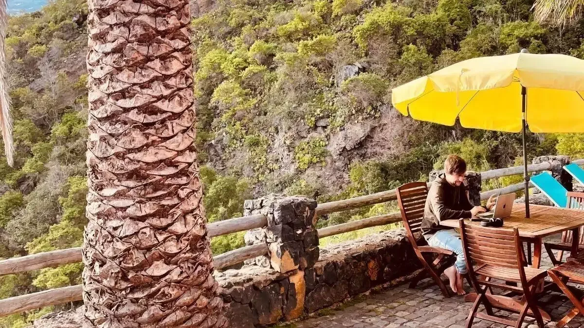 Person eine, die an einem tisch mit einem regenschirm sitzt.