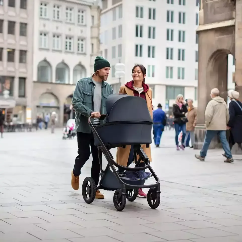 Ein mann und eine frau, die mit einem kinderwagen die.