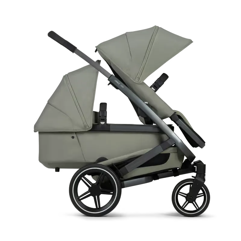 Kinderwagen ein mit grauer abdeckung und schwarzen rädern.